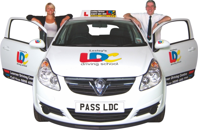 Driving instructor with learner driver next to car